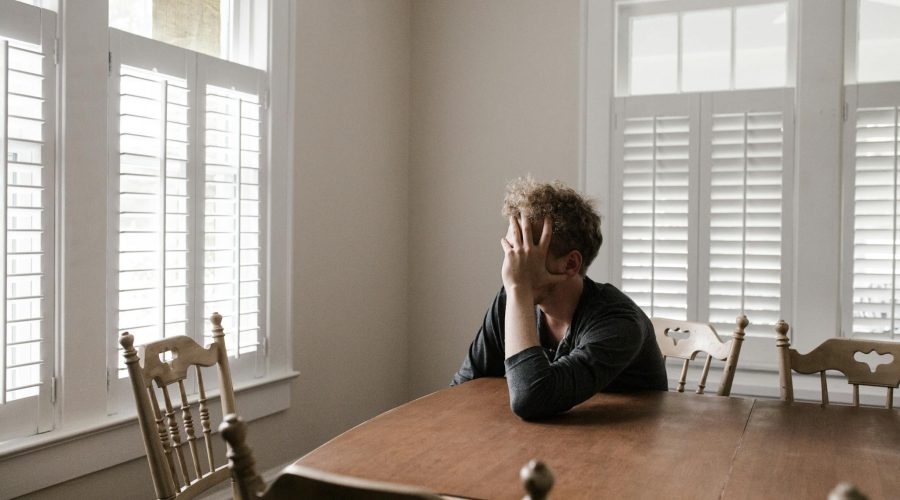 Photo of Man Leaning on Wooden Table