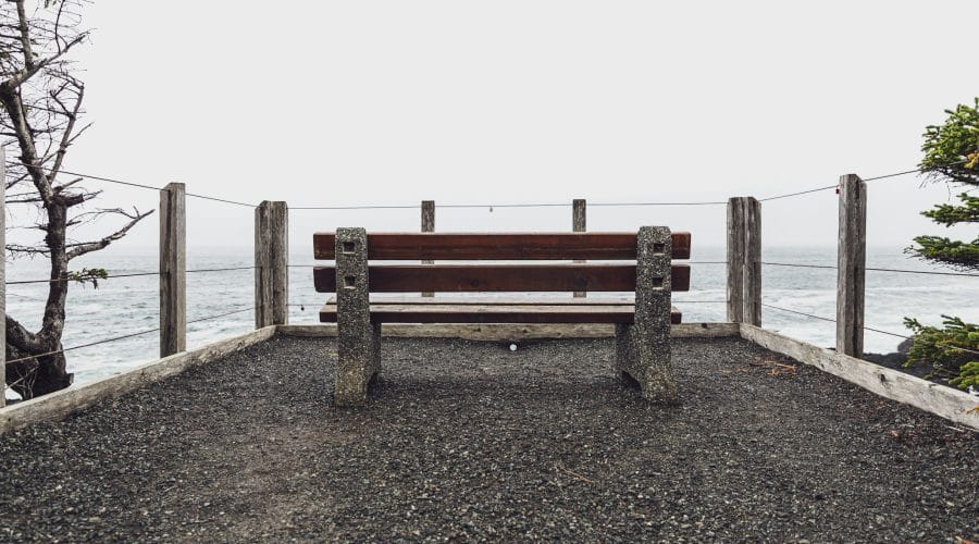 brown wooden bench on brown sand near body of water during daytime