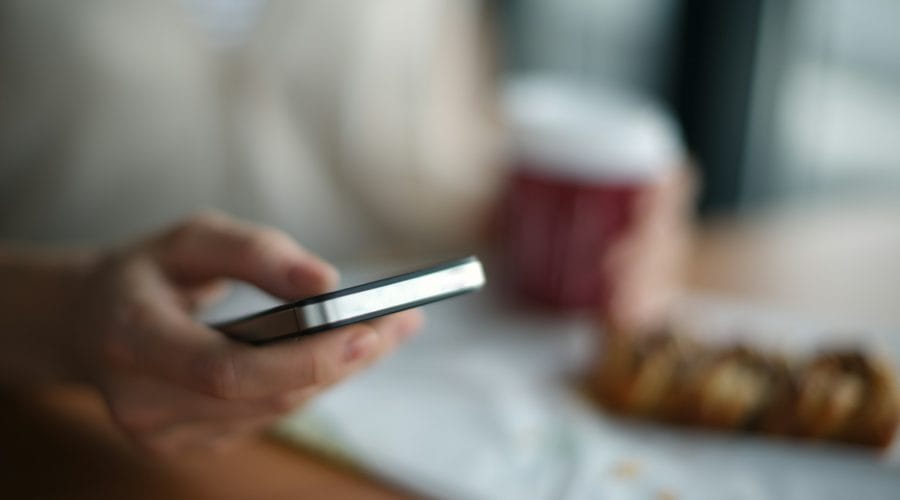selective focus photography of person holding gray phone