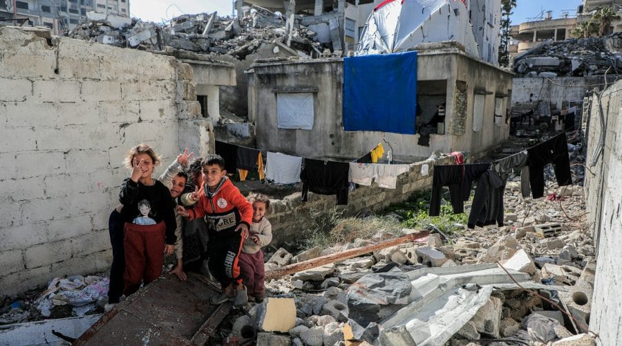A group of people standing next to a pile of rubble