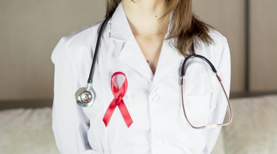 a female doctor wearing a red ribbon and a stethoscope